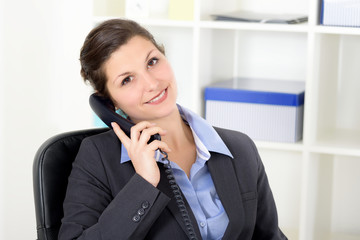 Attraktive Sekretärin telefoniert im Büro