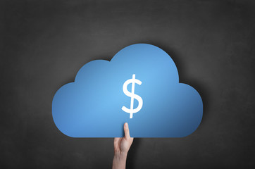 Businessman is holding a blue cloud dollar icon on black blackbo