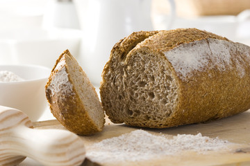 Whole wheat bread with flour on a cutting board.