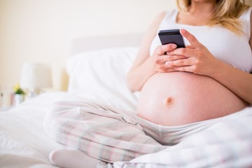 Pregnant woman using her smartphone 