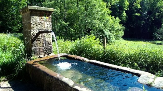 Brunnen mit fließendem klaren und kaltem Trinkwasser