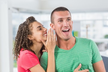 Casual businesswoman whispering secret to her colleague