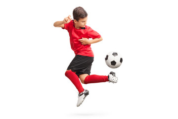 Obraz premium Junior piłkarz wykonujący trick