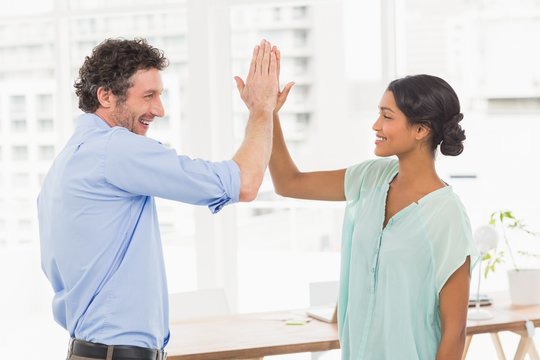  Casual businessman and woman high fiving