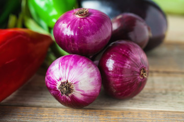Red onions, paprika and egg plant on wooden background