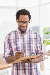 Fototapeta premium Smiling young businessman looking at the clipboard