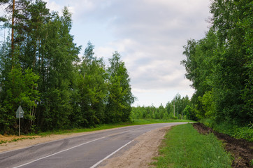 Fototapeta na wymiar narrow country road near a forest
