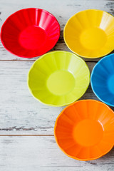 Colorful Ceramic Bowls on White Wooden Background