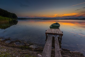 Beautiful lake sunset with fisherman boat
