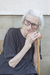 Portrait of a ninety years old grandma leaning on a walking stic