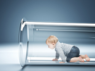 a few months old Caucasian baby crawling inside a glass test tube. in vitro fertilization concept.