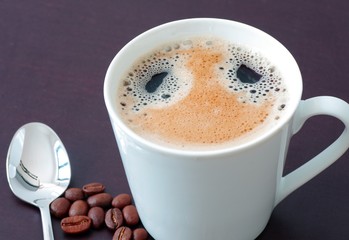 Kaffeetasse mit Kaffeelöffel und Kaffeebohnen