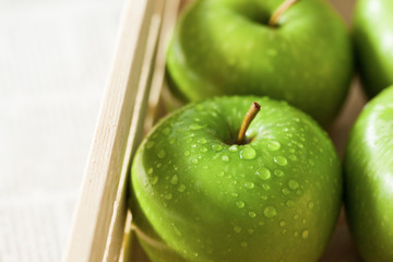 fresh green apples with water drop in wooden box