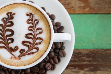 Latte art, coffee with coffee beans on wooden  background
