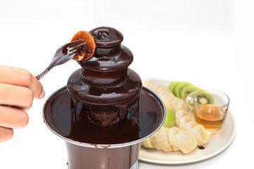 Slice of banana dipped in warm chocolate fondue.