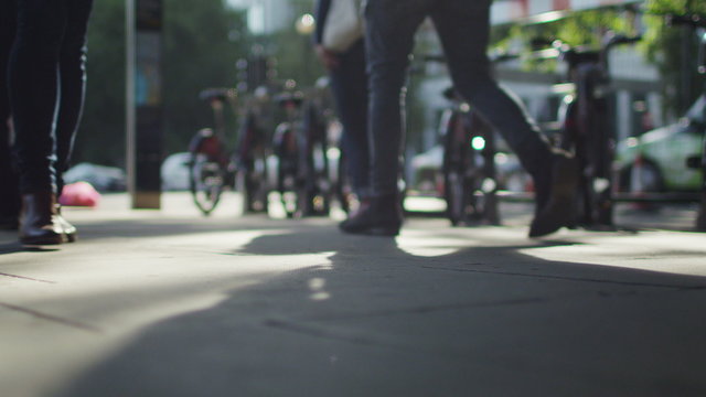 Blurred pedestrians walk past camera in slow motion