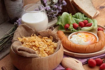 Obraz na płótnie Canvas Breakfast with eggs, sausage, bread, salad vegetables and milk.