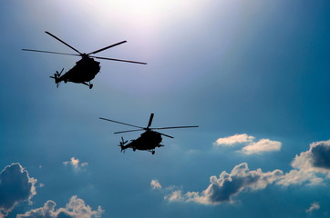 Fototapeta na wymiar silhouettes of two helicopters flying