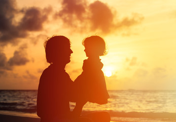Fototapeta premium Father and little daughter silhouettes at sunset