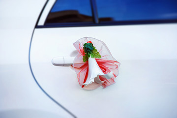 Closeup image of white flower as wedding auto decor at car door