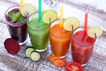 Vegetables, fresh juices mix fruit healthy drinks on wood table.