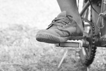 The boy foot on pedal of bicycle