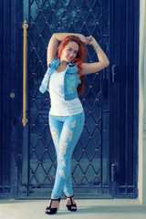 Full length portrait of sexy red haired women in blue jans posin