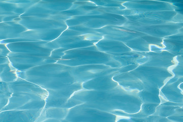 Naklejka na ściany i meble Blue pool water with sun reflections