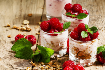 Homemade granola with yogurt, raspberry and mint  in glass bowls