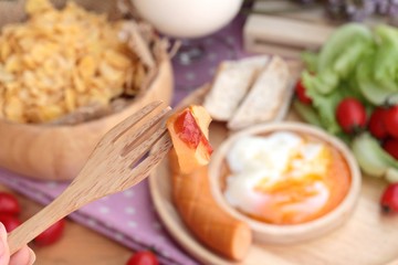Breakfast with eggs, sausage, bread, salad vegetables and milk.