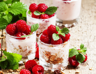 Homemade granola with yogurt, raspberry and mint  in glass bowls