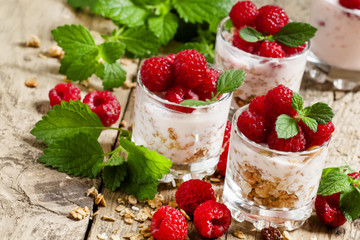 Homemade granola with yogurt, raspberry and mint  in glass bowls