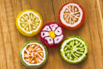 Five round colorful lollipops on wooden table,top view.