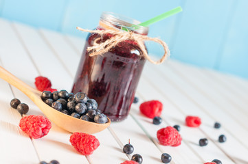 Blackberries jam in mason jar and fresh raspberry, blueberry on