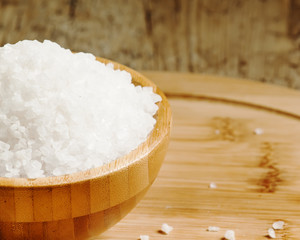 Large white sea salt in a wooden bowl, selective focus