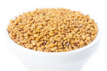 Fenugreek seeds in white bowl 
