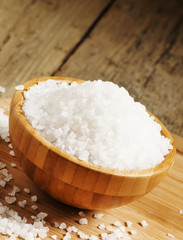 Fototapeta na wymiar Large white sea salt in a wooden bowl, selective focus