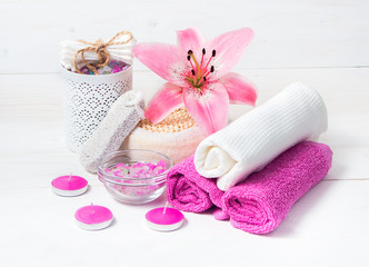 Fototapeta na wymiar Spa concept. Pink lily flower,sea salt, candles,towels