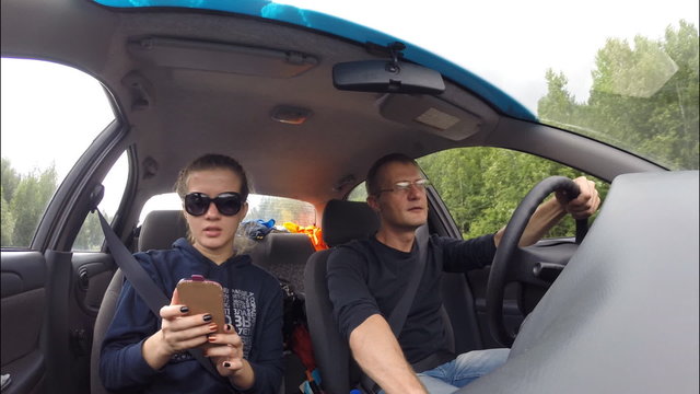 A family of two people traveling in the car. The camera inside the car 