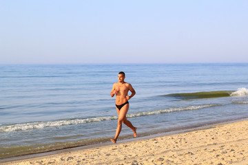 Fototapeta na wymiar young man jogging on the beach