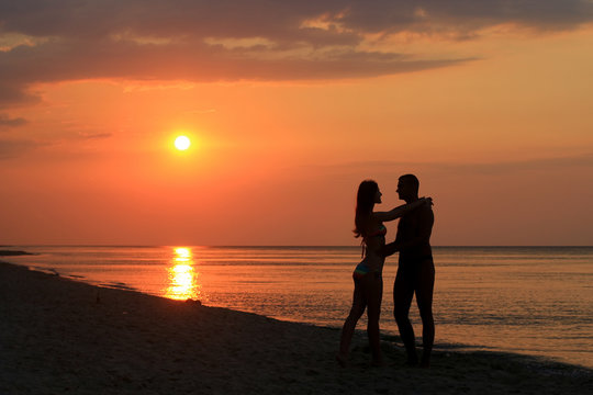love couple silhouette dancing on the beach at sunrise