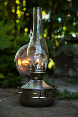 old kerosene lamp stands on the ground, outdoors