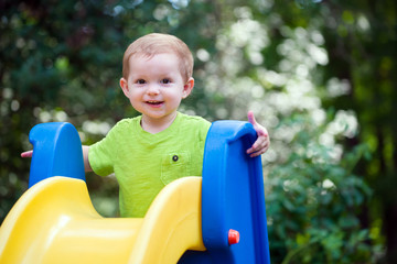 Young toddler boy child playing on slide