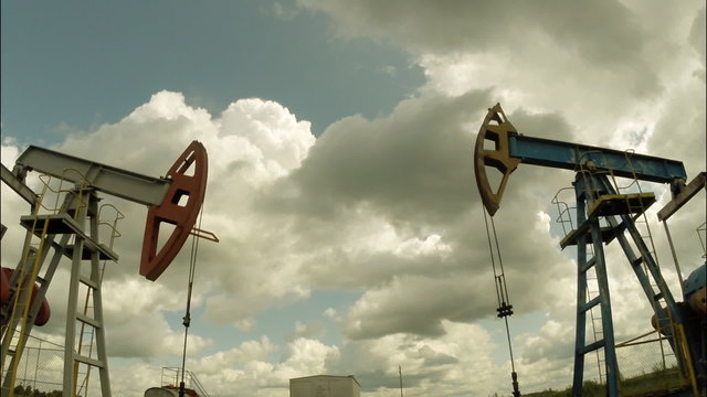 Oil pumps. Oil industry equipment. Storm clouds. moving camera 