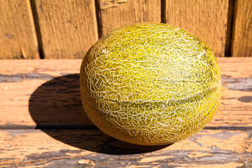 Melon on old weathered wooden surface, outdoors