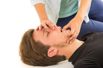 Closeup of unconscious male head and female hands holding his