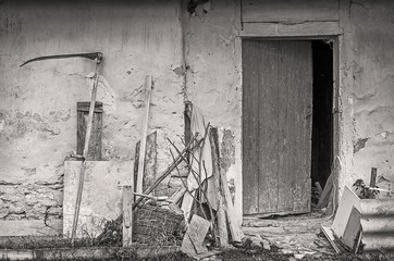 Farm tools near wall of old shed