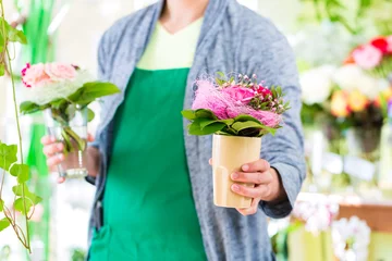 Deurstickers Bloemenwinkel Bloemist aan het werk in bloemenwinkel met potplanten