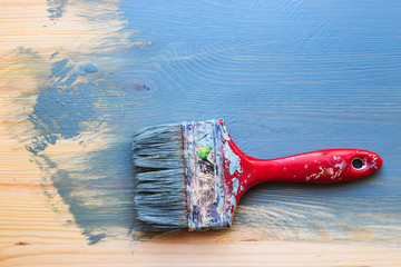 Old used paint brush on partial paint wood background. Horizonta