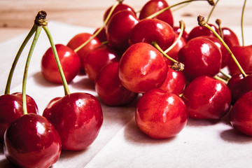 Healthy organic vegetarian super food cherries in clay dish on rustic kitchen table background. Dark photo, rustic style, natural light